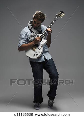 Studio shot of man playing electric guitar View Large Photo Image Stock Photo - Studio shot of man playing electric guitar. Fotosearch