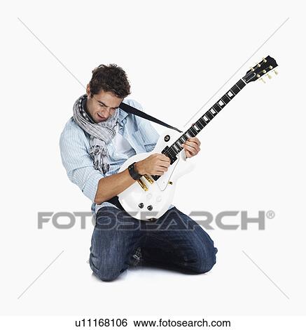 Studio shot of man playing electric guitar View Large Photo Image Stock Photograph - Studio shot of man playing electric guitar. Fotosearch