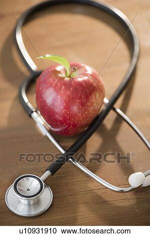 Stock Image - Studio shot of stethoscope and apple. Fotosearch