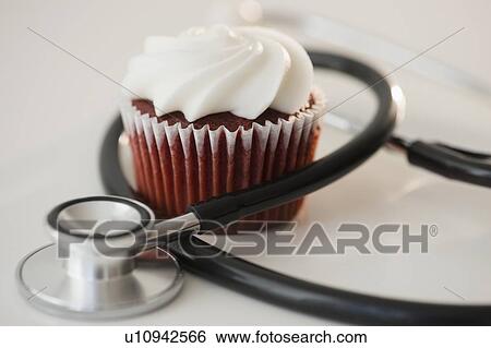 Stock Photograph - Studio shot of stethoscope and cupcake. Fotosearch