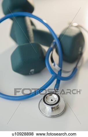 Stock Photo - Studio shot of stethoscope and dumbbells. Fotosearch