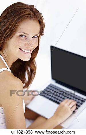 Stock Photo - Studio shot of woman using laptop. Fotosearch