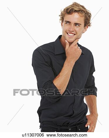 Stock Photograph - Studio Shot, Portrait of young man standing, hand on chin. Fotosearch