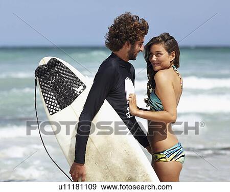 Surfer man and young woman on beach View Large Photo Image Stock Photo - Surfer man and young woman on beach. Fotosearch