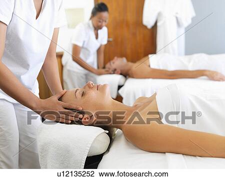 Stock Image - Two people getting massage in spa. Fotosearch