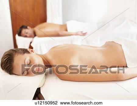 Stock Image - Two people getting massage in spa. Fotosearch