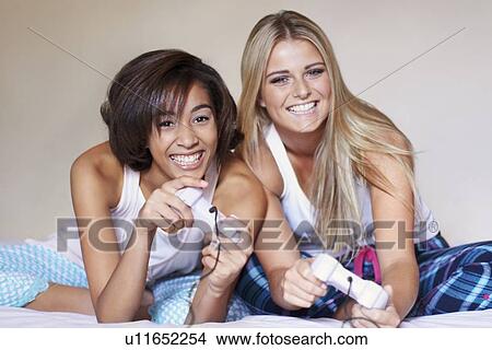 Two women playing video game View Large Photo Image Picture - Two women playing video game. Fotosearch