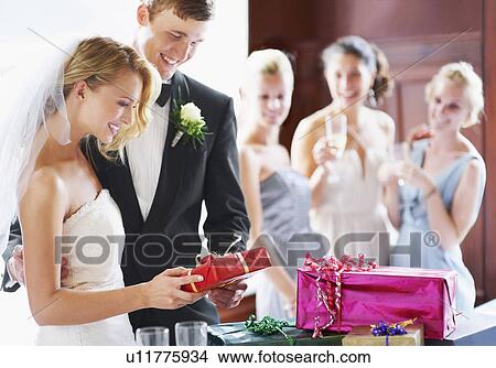 Wedding couple opening gifts View Large Photo Image Picture - Wedding couple opening gifts. Fotosearch