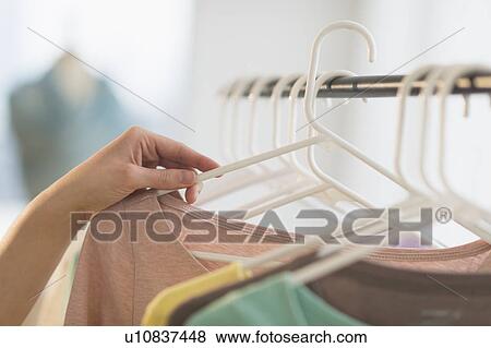 Stock Photo - Woman choosing blouse. Fotosearch