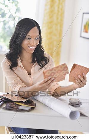 Stock Photo - Woman choosing color swatches. Fotosearch