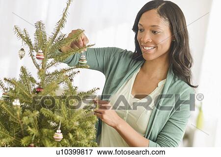 Woman decorating christmas tree View Large Photo Image Stock Photo - Woman decorating christmas tree. Fotosearch