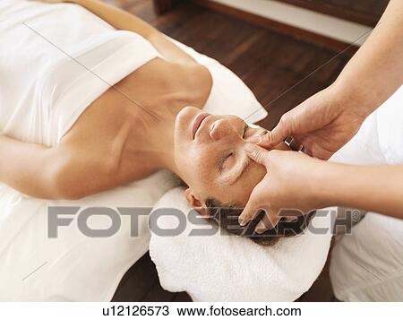 Stock Image - Woman getting facial massage in spa. Fotosearch