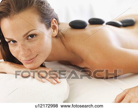 Stock Photo - Woman getting hot stone therapy in spa. Fotosearch