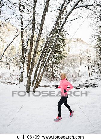 Stock Photo - Woman jogging in winter forest. Fotosearch