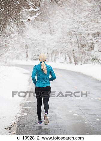 Stock Image - Woman jogging in winter . Fotosearch