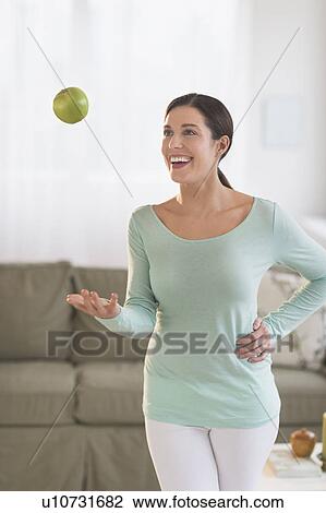 Woman juggling with apple at home View Large Photo Image Stock Image - Woman juggling with apple at home. Fotosearch