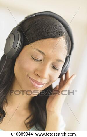 Picture - Woman listening to music on headphones. Fotosearch