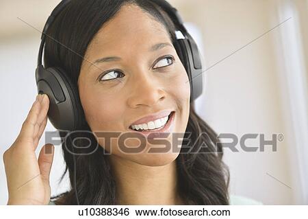 Woman listening to music on headphones View Large Photo Image Stock Photograph - Woman listening to music on headphones. Fotosearch