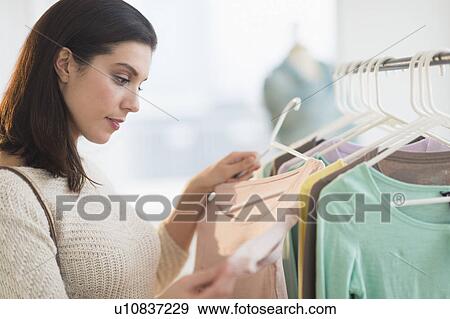Woman looking at blouses at store View Large Photo Image Stock Photo - Woman looking at blouses at store. Fotosearch