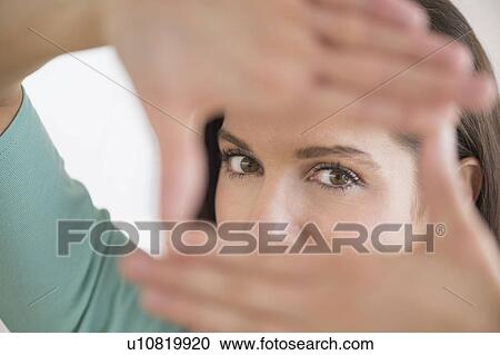 Woman looking at camera through handsframe View Large Photo Image Stock Image - Woman looking at camera through handsframe. Fotosearch