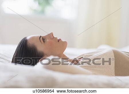 Woman lying on bed View Large Photo Image Picture - Woman lying on bed. Fotosearch