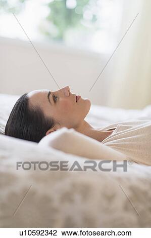 Woman lying on bed View Large Photo Image Stock Image - Woman lying on bed. Fotosearch