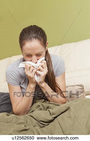 Woman on sofa blowing her nose View Large Photo Image Stock Image - Woman on sofa blowing her nose. Fotosearch