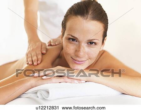 Stock Image - Woman relaxing while getting massage. Fotosearch
