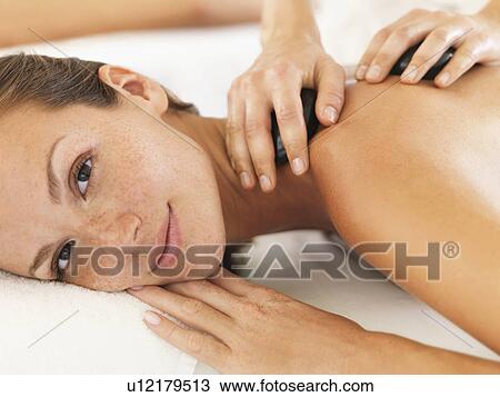 Woman relaxing while getting stone massage View Large Photo Image Stock Image - Woman relaxing while getting stone massage. Fotosearch