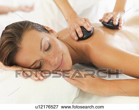Woman relaxing while getting stone massage View Large Photo Image Stock Photo - Woman relaxing while getting stone massage. Fotosearch