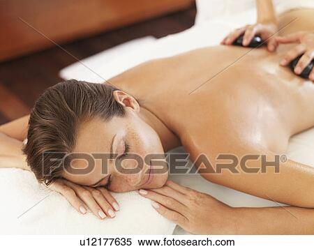 Woman relaxing while getting stone massage View Large Photo Image Stock Photography - Woman relaxing while getting stone massage. Fotosearch