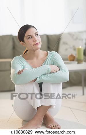 Woman sitting in living room View Large Photo Image Stock Photo - Woman sitting in living room. Fotosearch