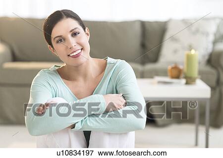 Stock Photo - Woman sitting in living room. Fotosearch