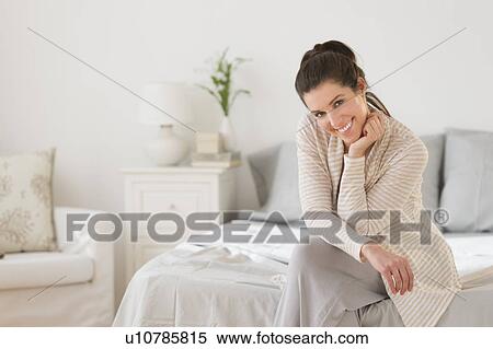 Stock Photography - Woman sitting on bed. Fotosearch