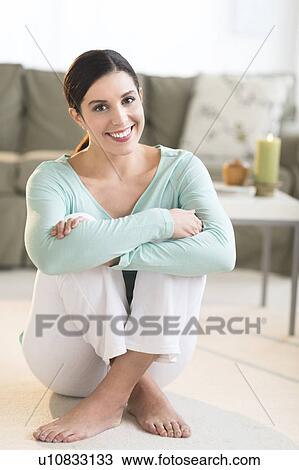 Woman sitting on floor in living room View Large Photo Image Stock Image - Woman sitting on floor in living room. Fotosearch