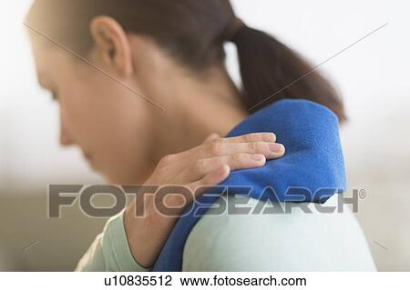 Stock Image - Woman touching aching back. Fotosearch