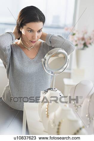 Woman trying on necklace View Large Photo Image Stock Image - Woman trying on necklace. Fotosearch