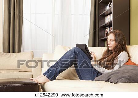 Stock Image - Woman using digital tablet at home. Fotosearch