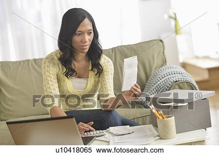 Woman using laptop and going through bills View Large Photo Image Stock Photography - Woman using laptop and going through bills. Fotosearch