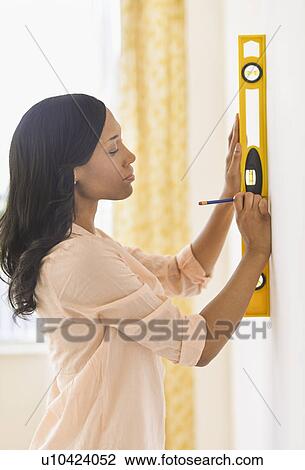 Woman using spirit level View Large Photo Image Stock Image - Woman using spirit level. Fotosearch