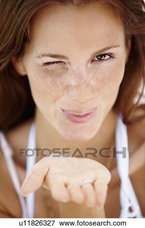 Woman winking and blowing a kiss View Large Photo Image Stock Photo - Woman winking and blowing a kiss. Fotosearch