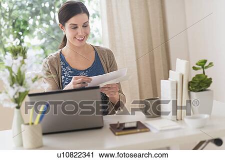 Stock Image - Woman working in home office. Fotosearch
