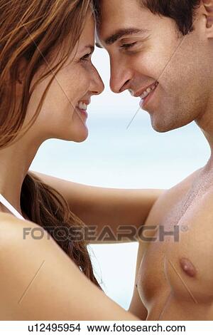 Young attractive couple enjoying summer holiday on beach View Large Photo Image Picture - Young attractive couple enjoying summer holiday on beach. Fotosearch
