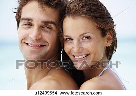 Picture - Young attractive couple enjoying summer holiday on beach. Fotosearch