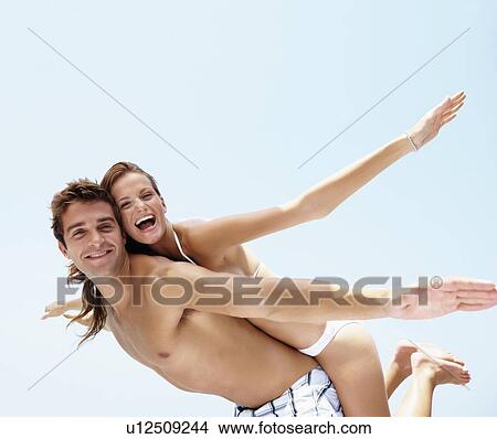 Young attractive couple enjoying summer holiday on beach View Large Photo Image Picture - Young attractive couple enjoying summer holiday on beach. Fotosearch
