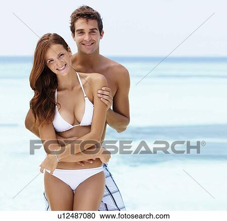Young attractive couple enjoying summer holiday on beach View Large Photo Image Stock Image - Young attractive couple enjoying summer holiday on beach. Fotosearch
