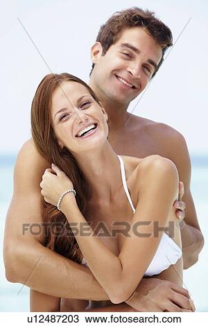 Stock Image - Young attractive couple enjoying summer holiday on beach. Fotosearch