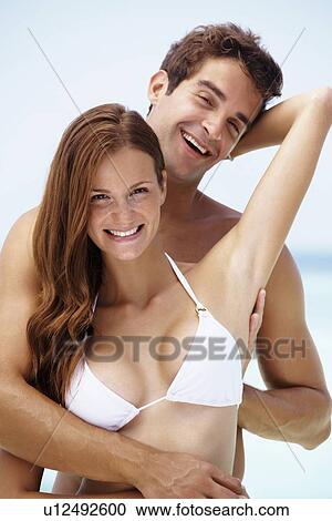 Stock Image - Young attractive couple enjoying summer holiday on beach. Fotosearch
