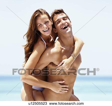 Stock Image - Young attractive couple enjoying summer holiday on beach. Fotosearch