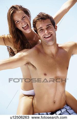 Young attractive couple enjoying summer holiday on beach View Large Photo Image Stock Image - Young attractive couple enjoying summer holiday on beach. Fotosearch